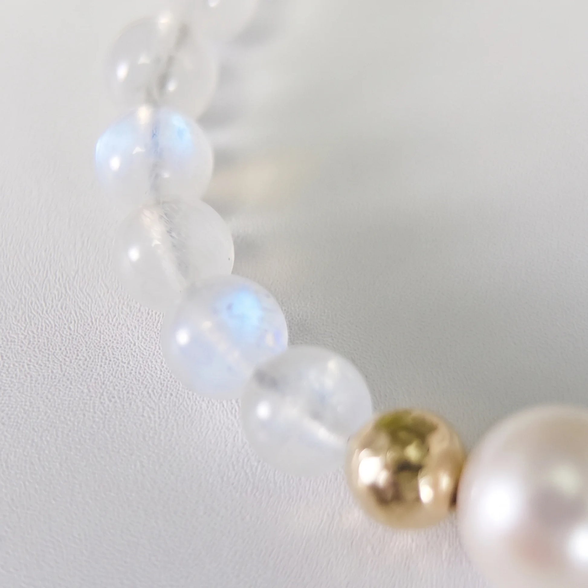 Rainbow moonstone, pearl and initial gold bracelet featuring luminous gemstone beads, lustrous freshwater pearls and a personalised gold-filled stamped initial disc.