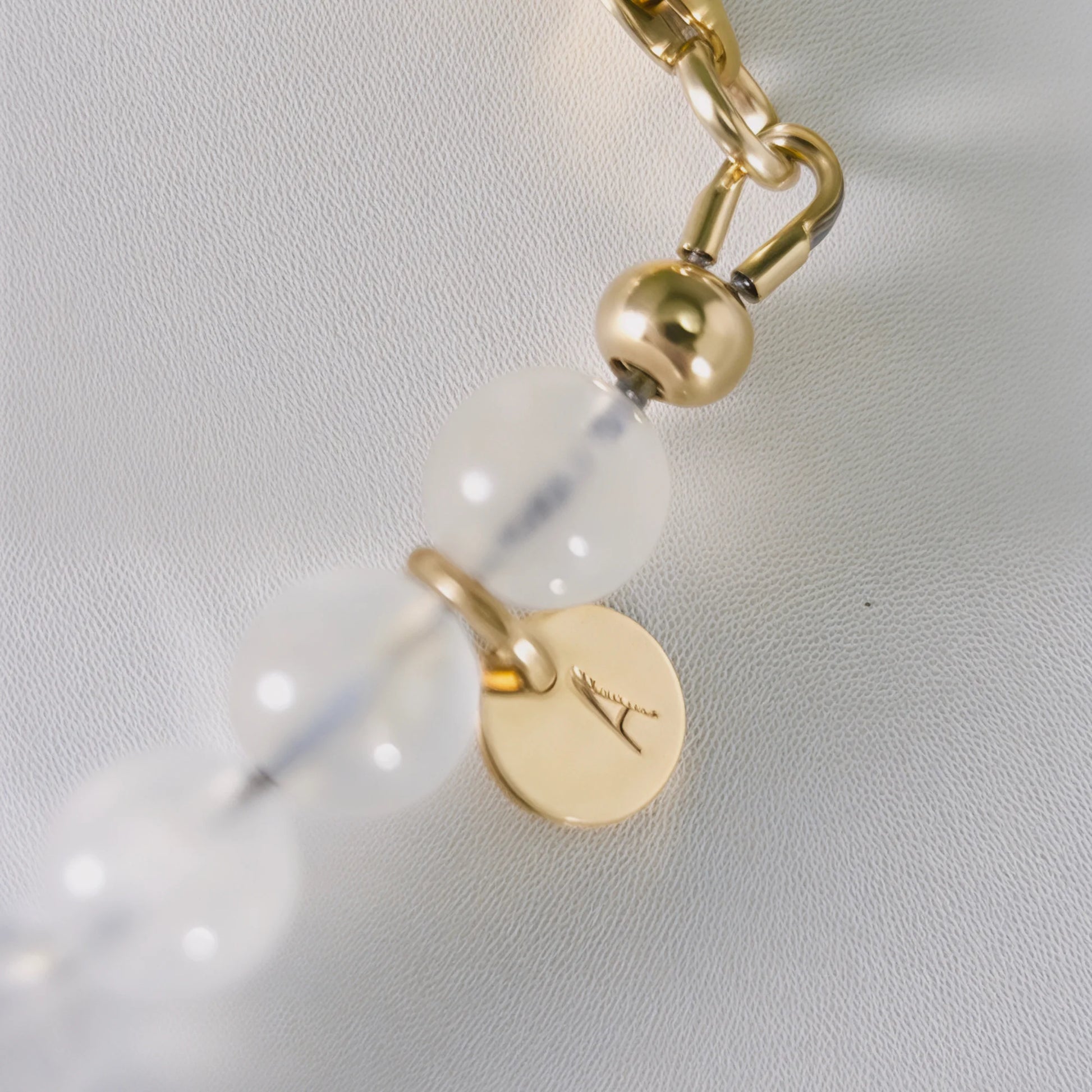 Rainbow moonstone, pearl and initial gold bracelet featuring luminous gemstone beads, lustrous freshwater pearls and a personalised gold-filled stamped initial disc.