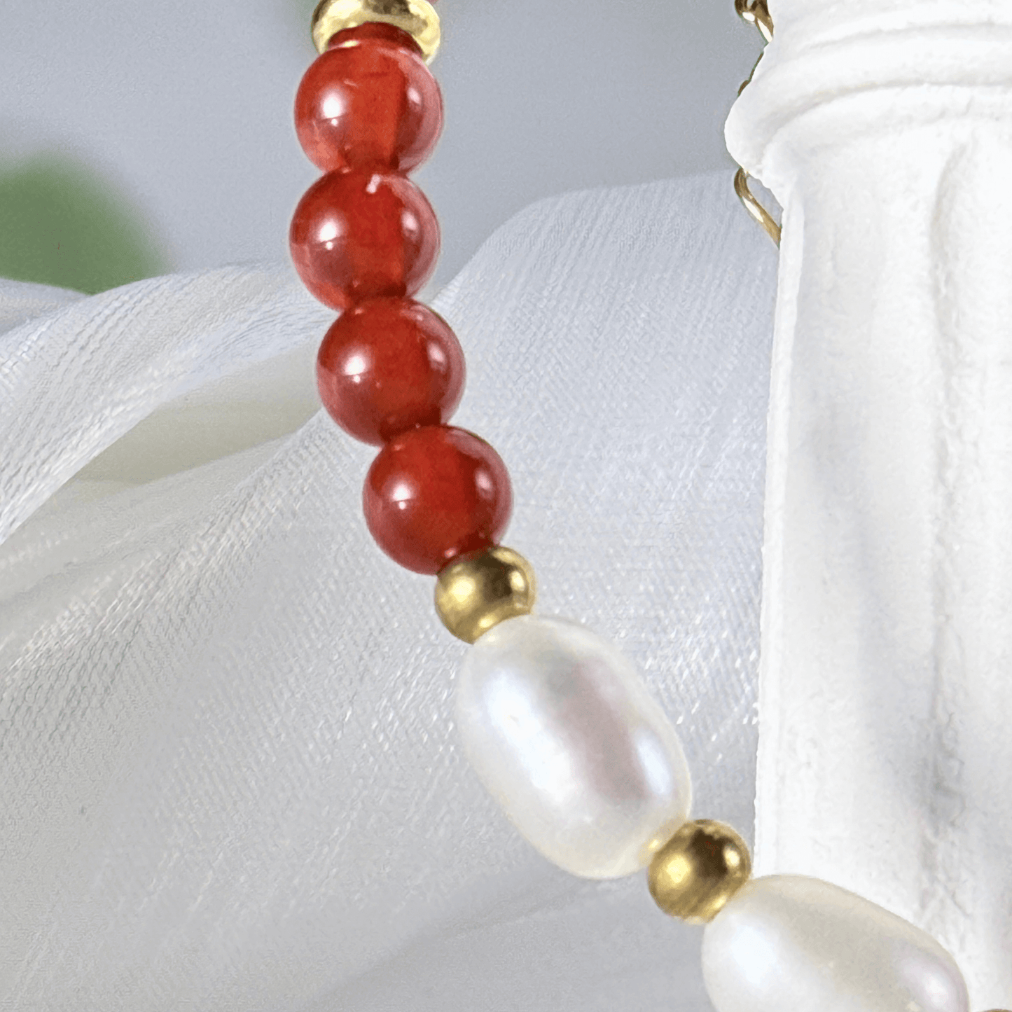 Handmade bracelet with red agate beads and freshwater pearl accents, finished with gold or silver findings.