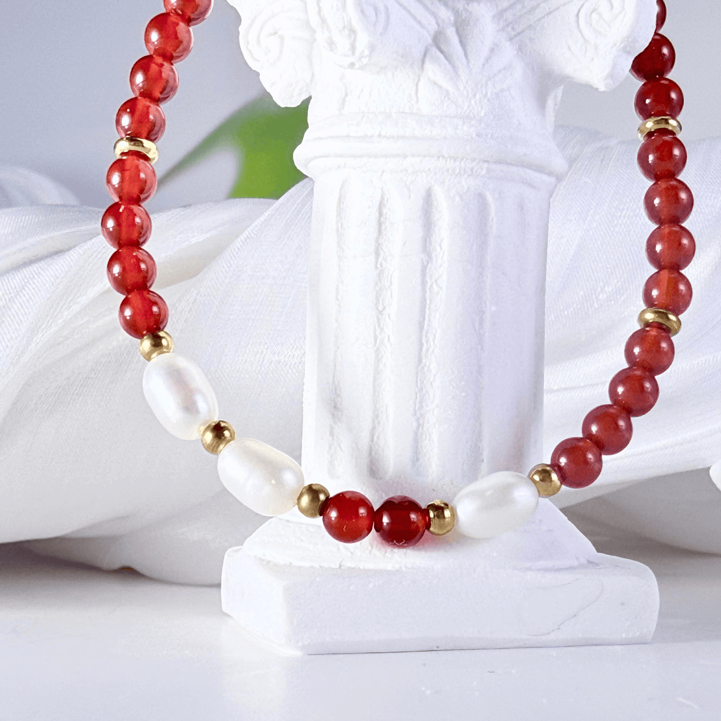 Handmade bracelet with red agate beads and freshwater pearl accents, finished with gold or silver findings.