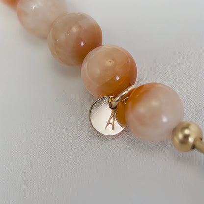 A 14k gold filled beaded bracelet featuring red rabbit hair quartz and premium freshwater pearl with stamped initial disc - MXW Jewellery
