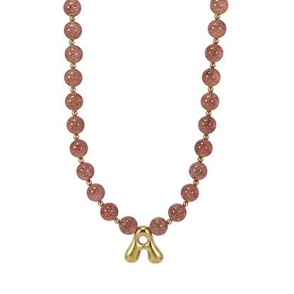 MXW Jewellery Red strawberry quartz beaded necklace with a gold bubble initial pendant.
