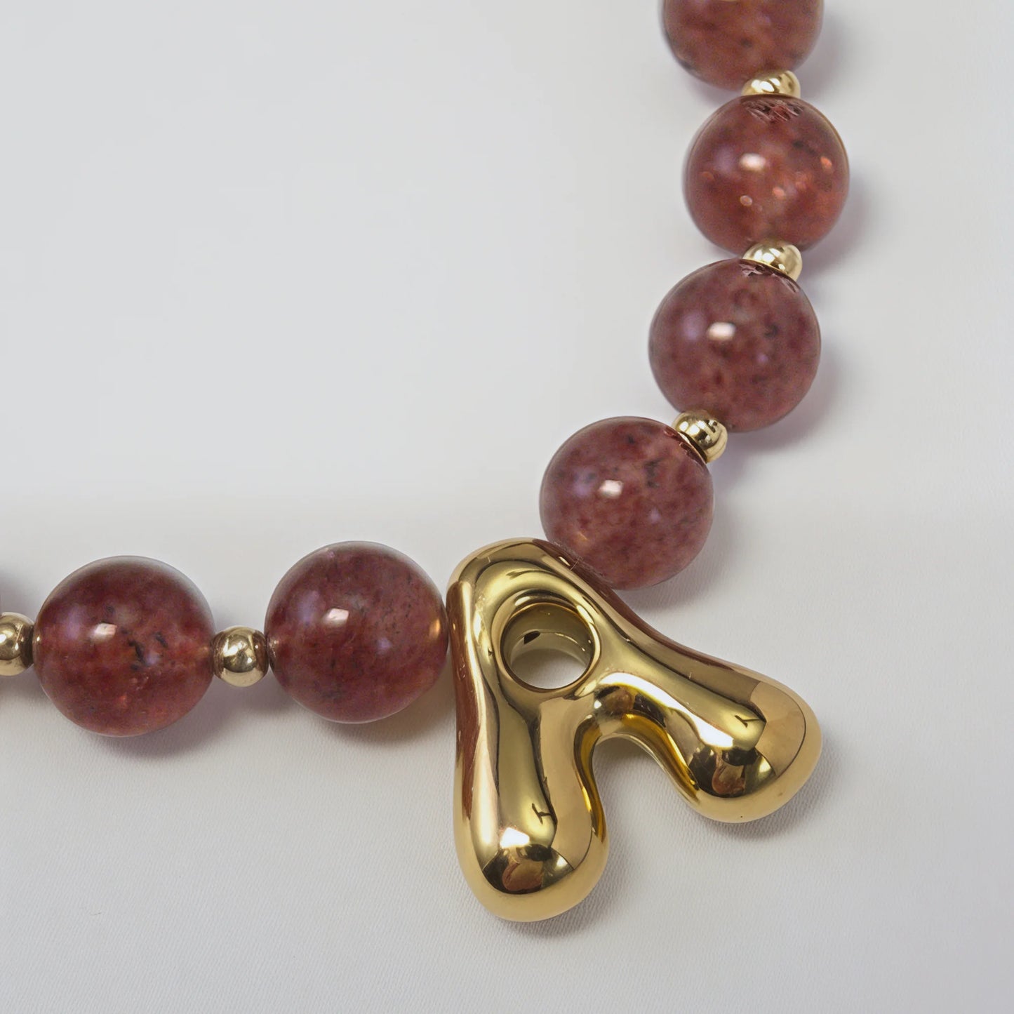 MXW Jewellery Red strawberry quartz beaded necklace with a gold bubble initial pendant.