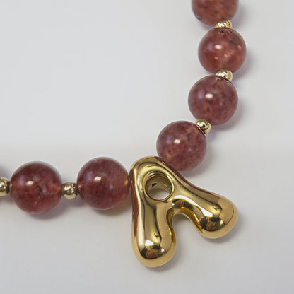 MXW Jewellery Red strawberry quartz beaded necklace with a gold bubble initial pendant.