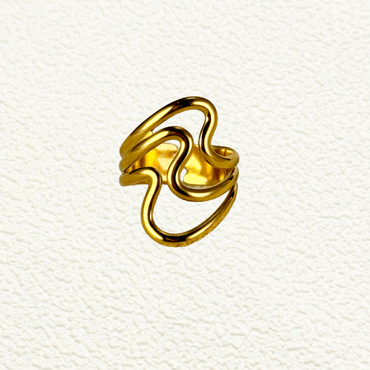 Gold retro-style ring with sculptural wavy open design on a neutral background.
