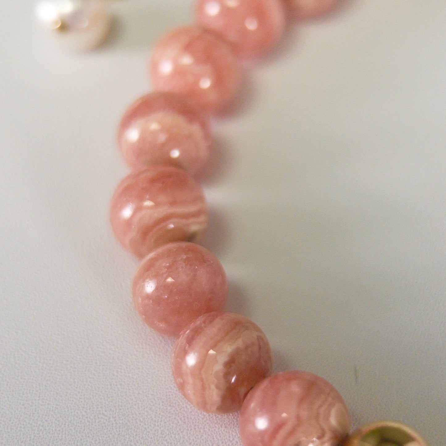 Rhodochrosite, pearl and initial gold bracelet featuring natural pink gemstone beads, lustrous freshwater pearls and a personalised gold-filled stamped initial disc.