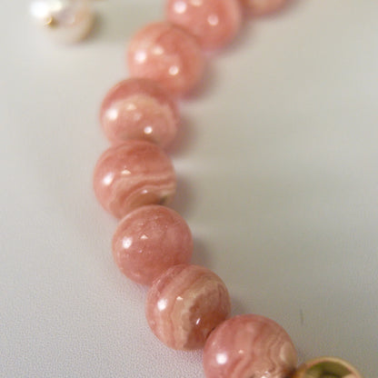 Rhodochrosite, pearl and initial gold bracelet featuring natural pink gemstone beads, lustrous freshwater pearls and a personalised gold-filled stamped initial disc.
