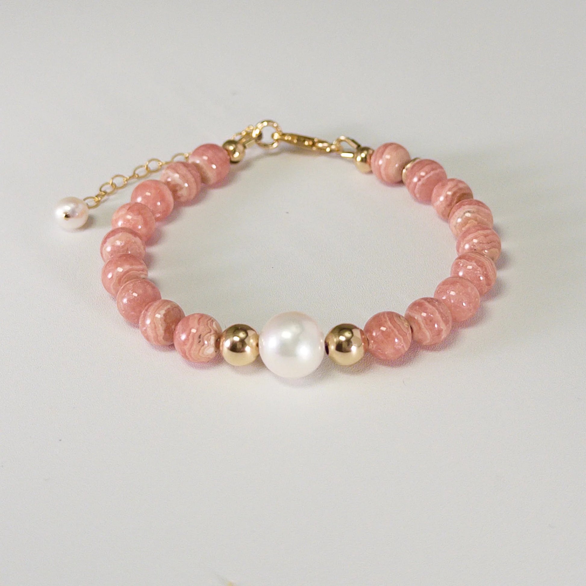 Rhodochrosite, pearl and initial gold bracelet featuring natural pink gemstone beads, lustrous freshwater pearls and a personalised gold-filled stamped initial disc.