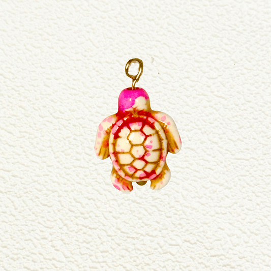Synthetic stone turtle charm in pink and cream tones with hexagon shell detailing and gold hardware