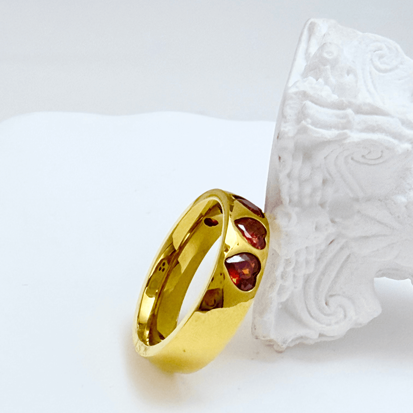 Gold ring with ruby-red heart-shaped zircon stones in a continuous band, waterproof jewellery by MXW.
