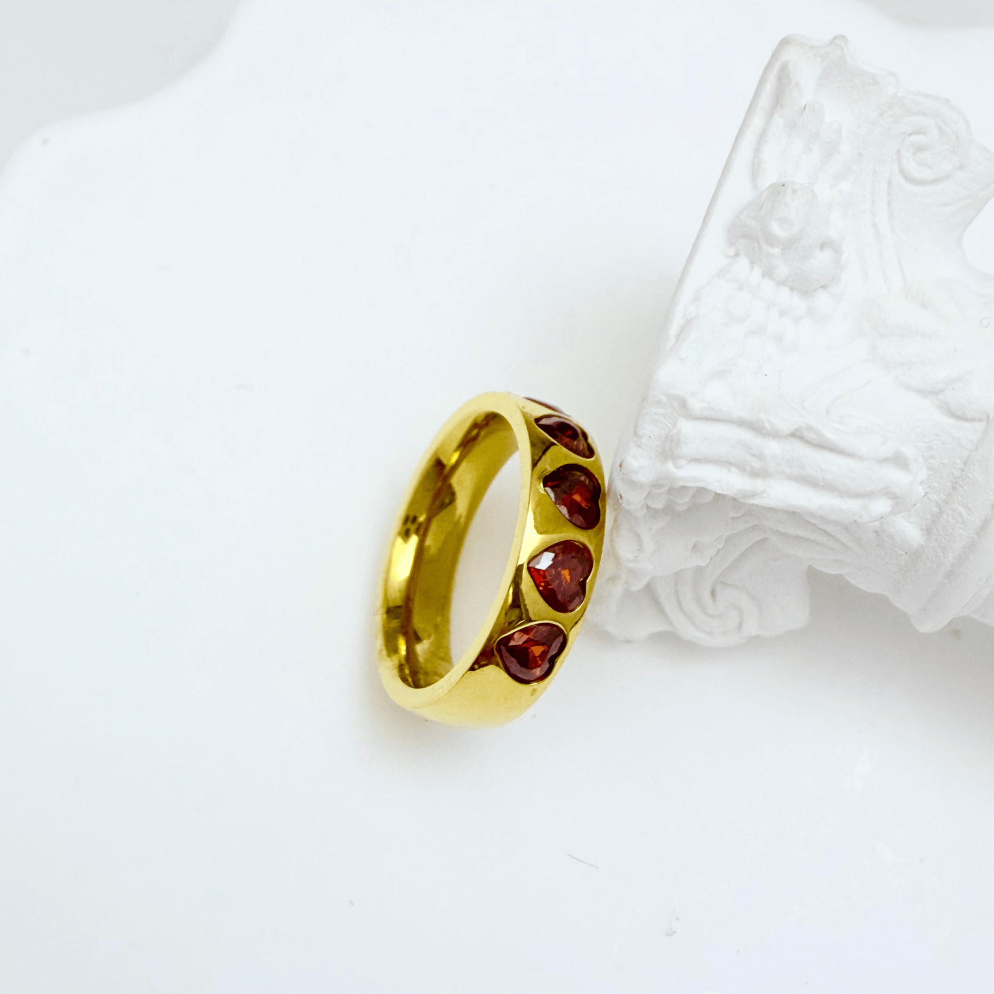 Gold ring with ruby-red heart-shaped zircon stones in a continuous band, waterproof jewellery by MXW.