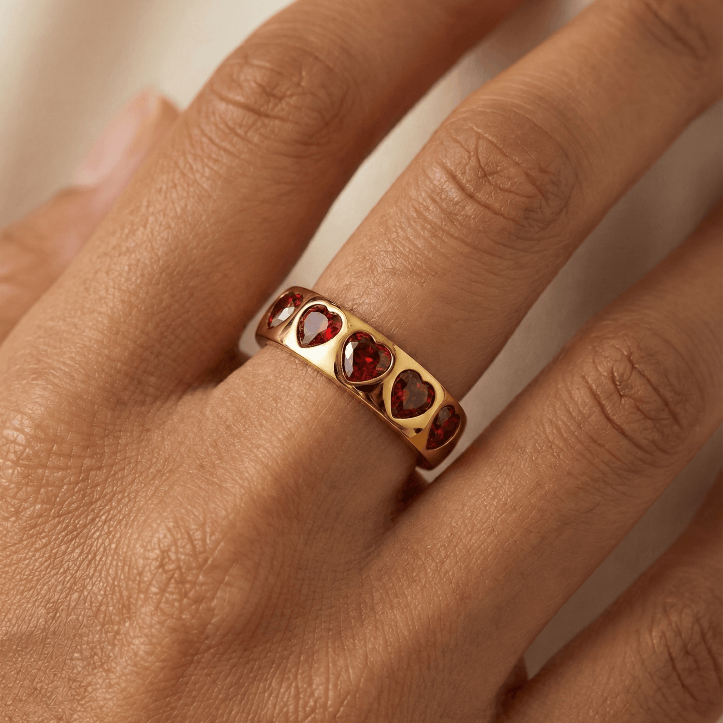 Gold ring with ruby-red heart-shaped zircon stones in a continuous band, waterproof jewellery by MXW.