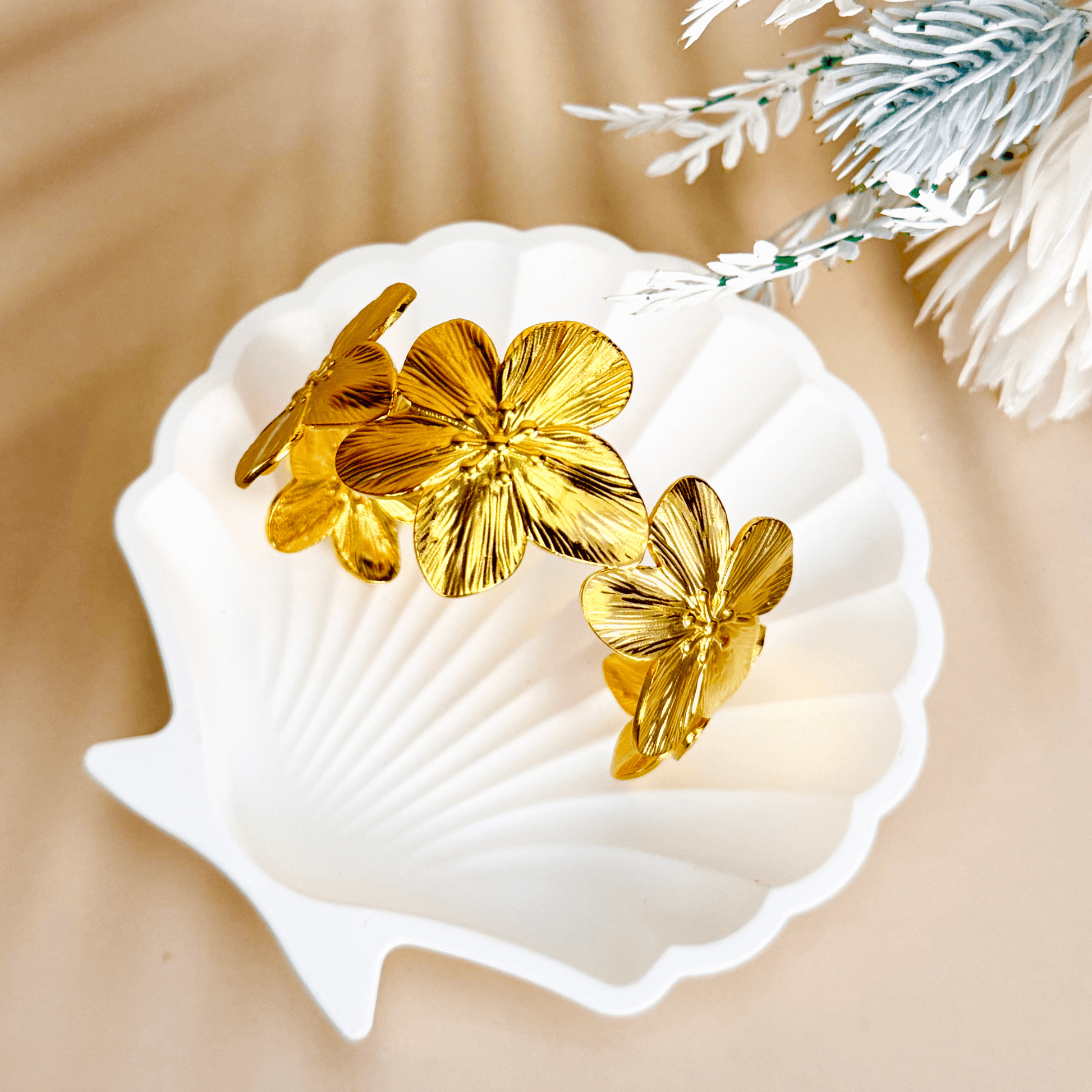 Gold floral open cuff bangle bracelet featuring five sculpted flowers in PVD gold-plated stainless steel – waterproof and tarnish-resistant statement jewellery piece.