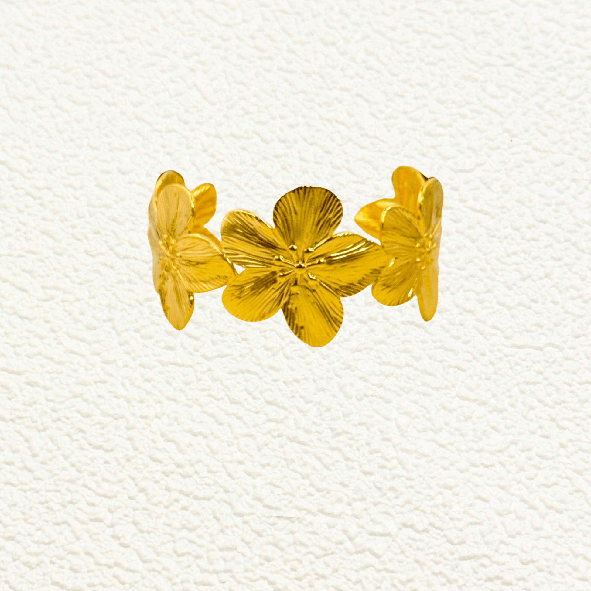 Gold floral open cuff bangle bracelet featuring five sculpted flowers in PVD gold-plated stainless steel – waterproof and tarnish-resistant statement jewellery piece.