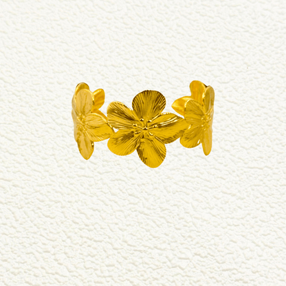 Gold floral open cuff bangle bracelet featuring five sculpted flowers in PVD gold-plated stainless steel – waterproof and tarnish-resistant statement jewellery piece.