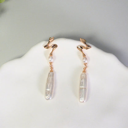 MXW gold vermeil drop earrings with a sculpted wave stud, a round freshwater pearl and a long baroque pearl drop.