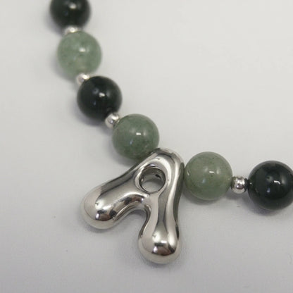 sterling silver necklace with alternating nephrite jade and green aventurine beads and a bubble letter pendant.