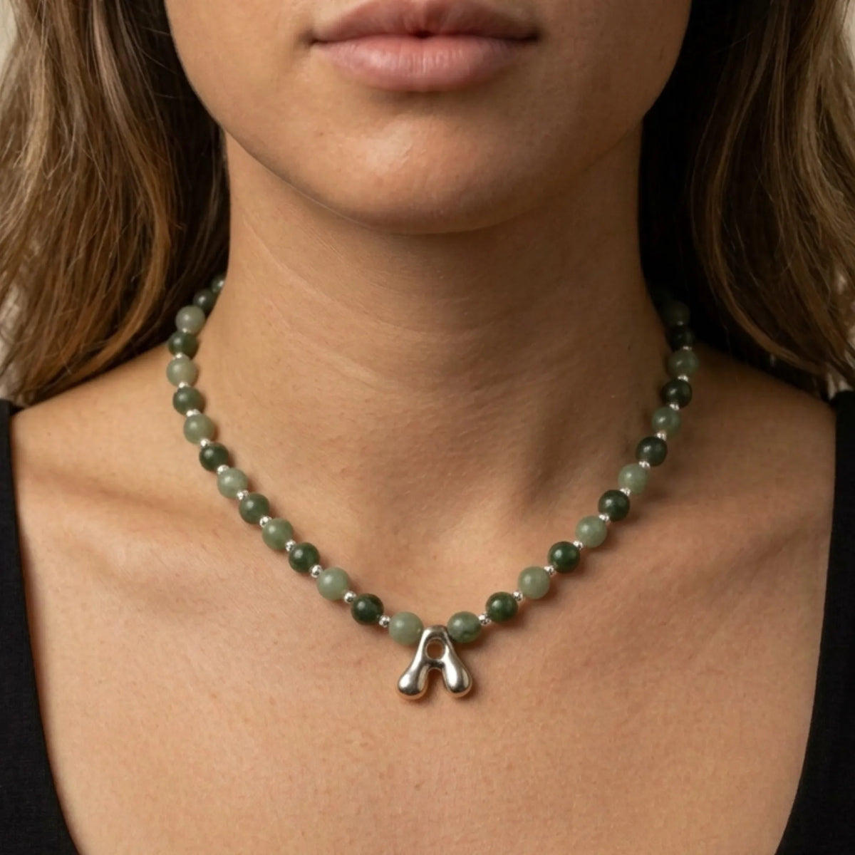 sterling silver necklace with alternating nephrite jade and green aventurine beads and a bubble letter pendant.