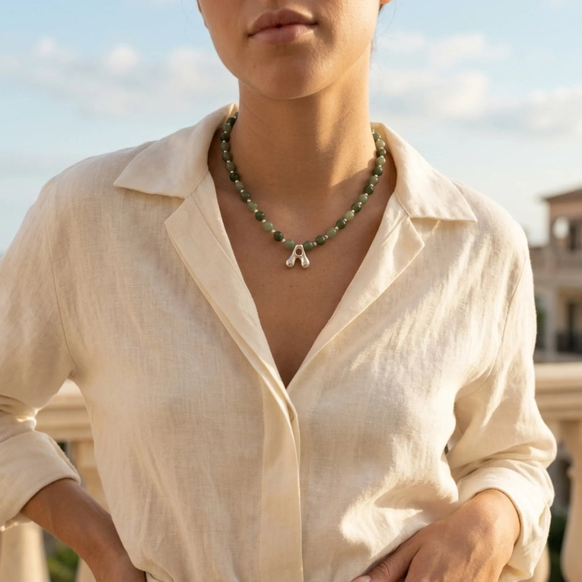 sterling silver necklace with alternating nephrite jade and green aventurine beads and a bubble letter pendant.