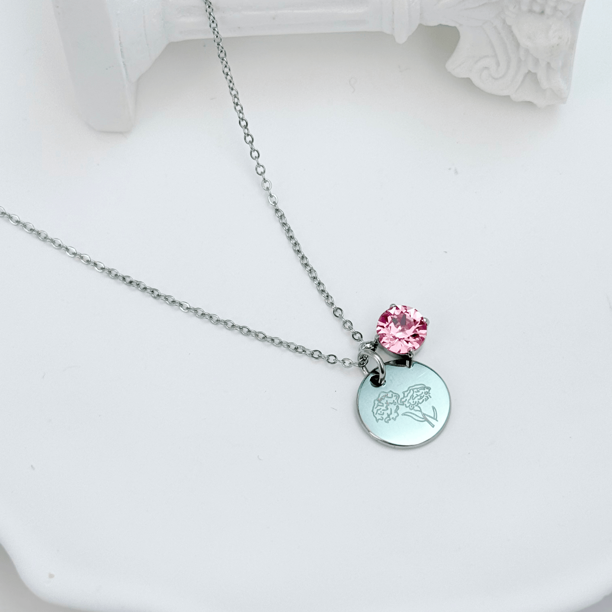 silver birth month necklace with blue crystal and engraved flower pendant