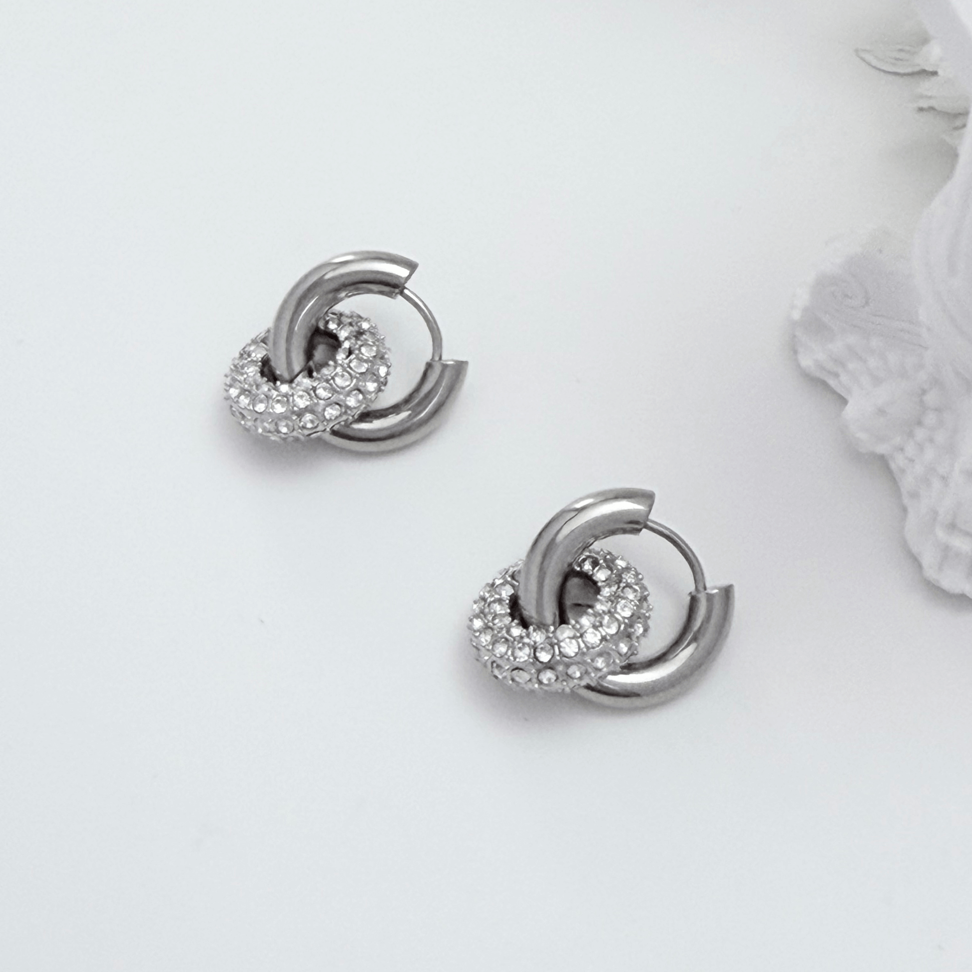 Modern silver hoop earrings with round crystal halo charm