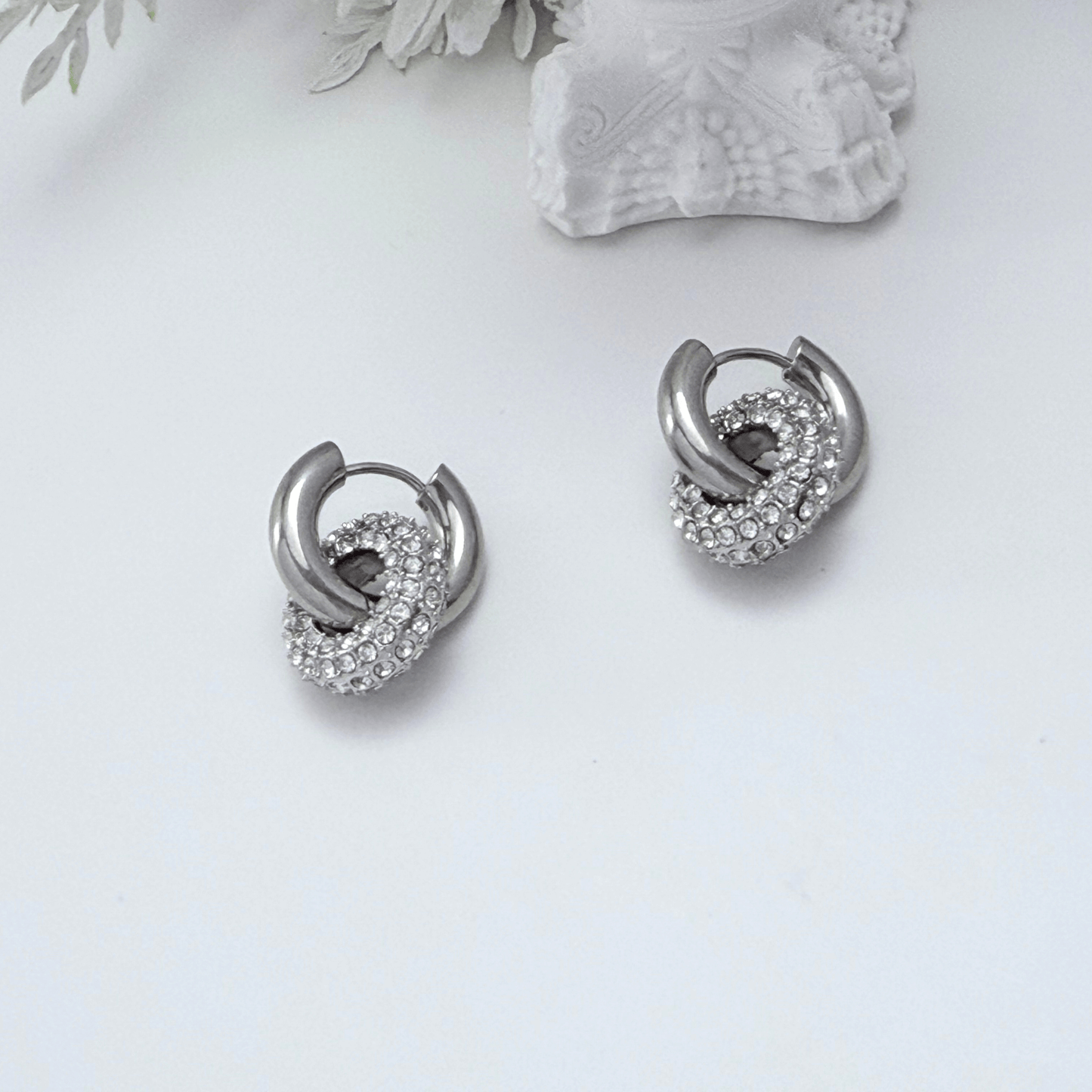 Modern silver hoop earrings with round crystal halo charm