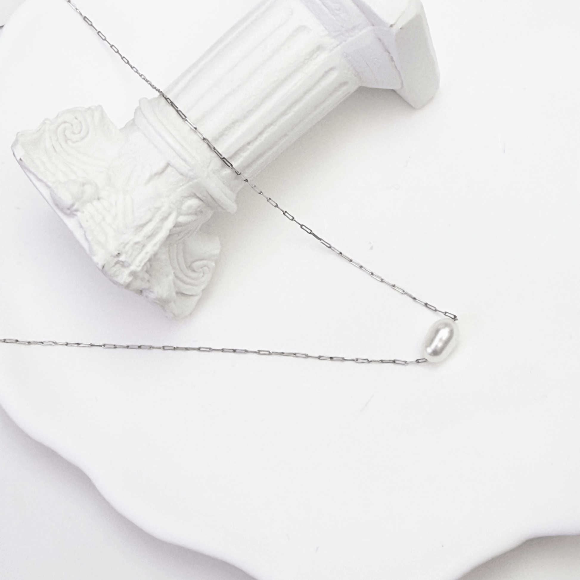 Dainty gold chain necklace with single freshwater pearl, minimalist waterproof design for layering or everyday wear.