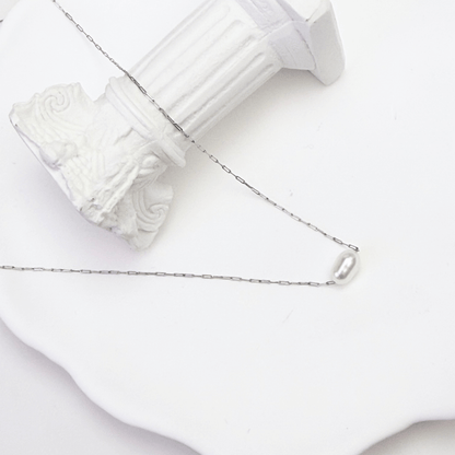 Dainty gold chain necklace with single freshwater pearl, minimalist waterproof design for layering or everyday wear.