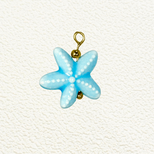 Light blue starfish-shaped charm with white dotted texture and gold hardware