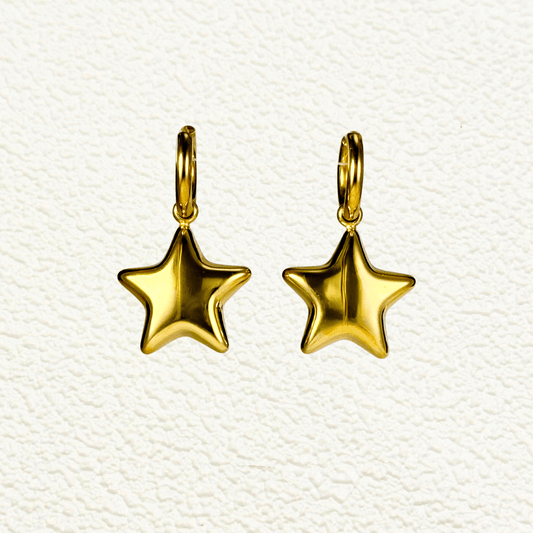 Gold hoop earrings with puffed star charms, made of PVD gold-plated stainless steel, displayed on a white stand.