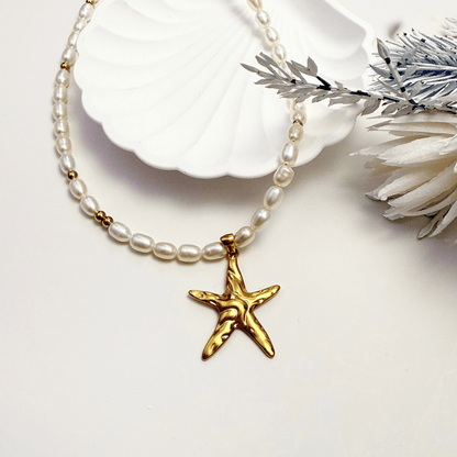 Pearl necklace with a gold starfish pendant on a white background