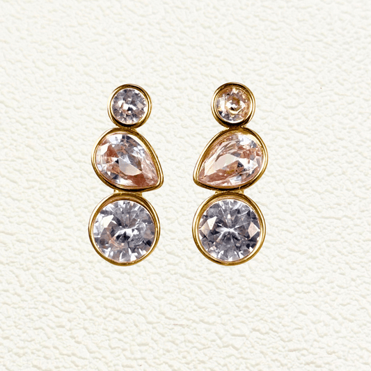Gold-plated stud earrings featuring three bezel-set zircon stones in round, teardrop, and circular cuts arranged vertically in a modern, elegant style.