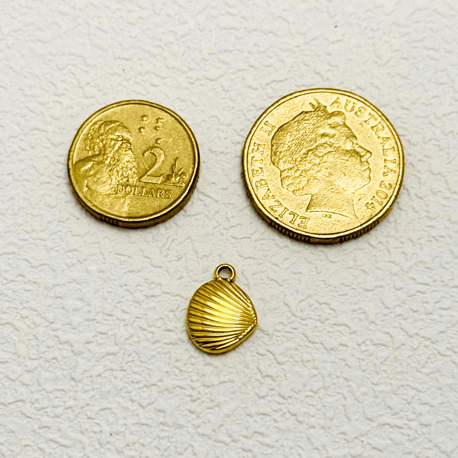 Gold clam shell charm with fine vertical ridges, PVD gold plated finish