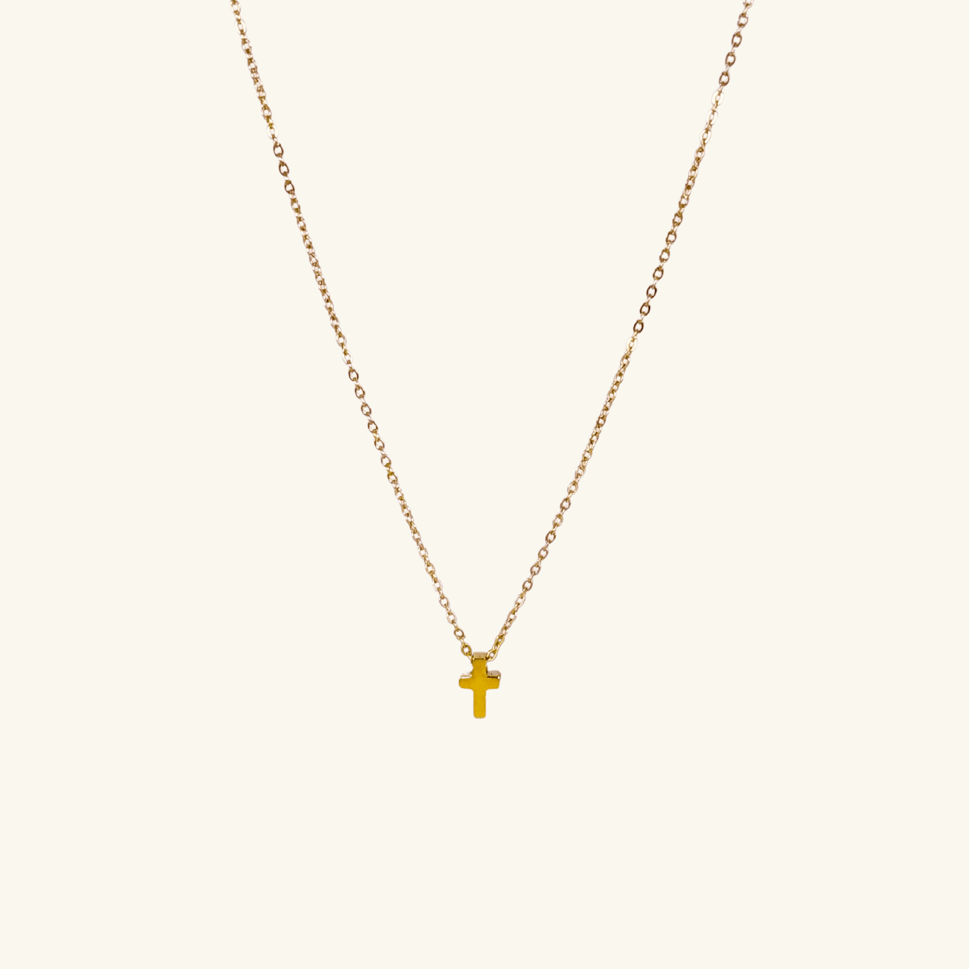 Minimalist gold tiny cross necklace on a fine chain, waterproof and tarnish-resistant, worn close to the neck