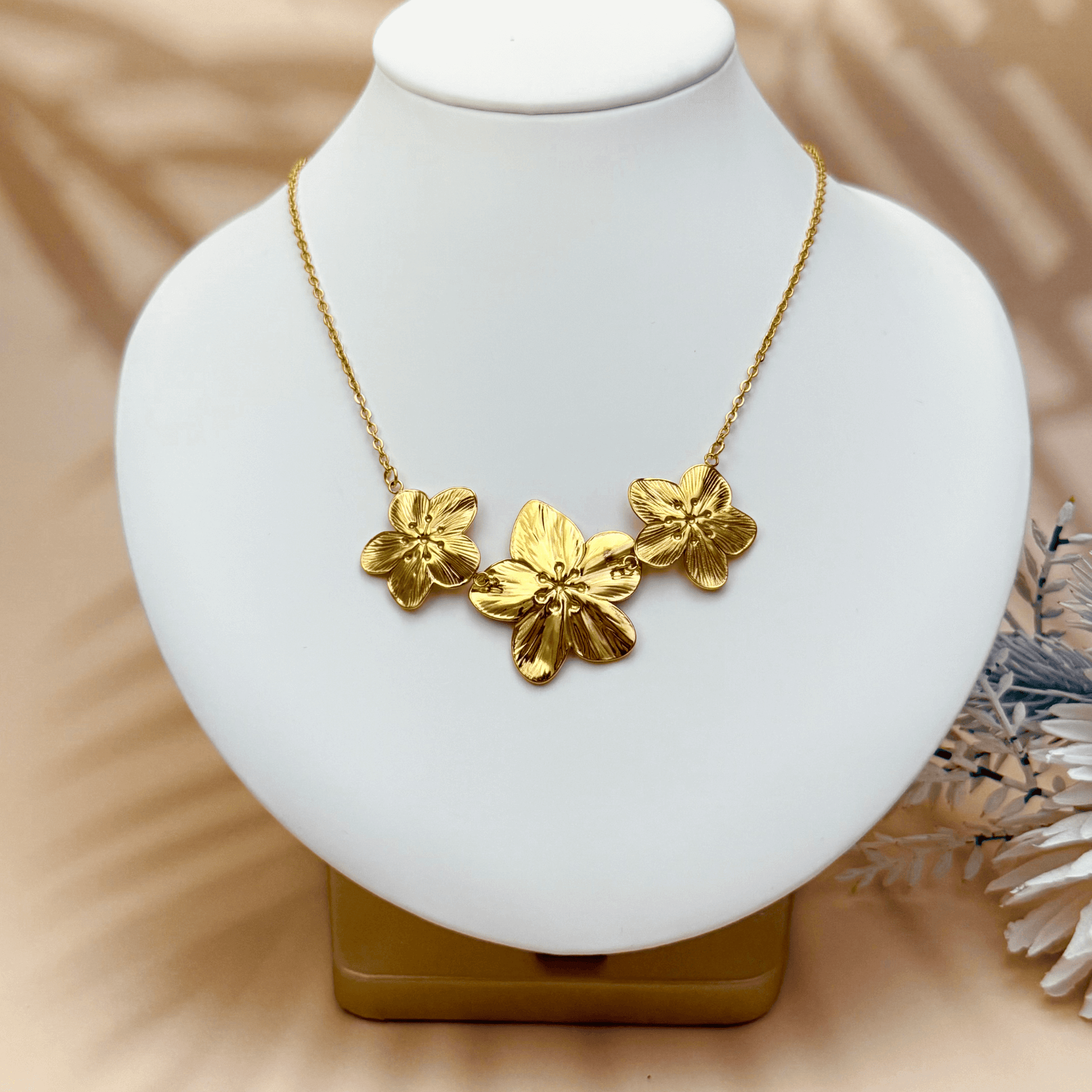 Gold triple flower pendant necklace with detailed floral design, made from waterproof PVD gold-plated stainless steel, displayed on a neutral background.
