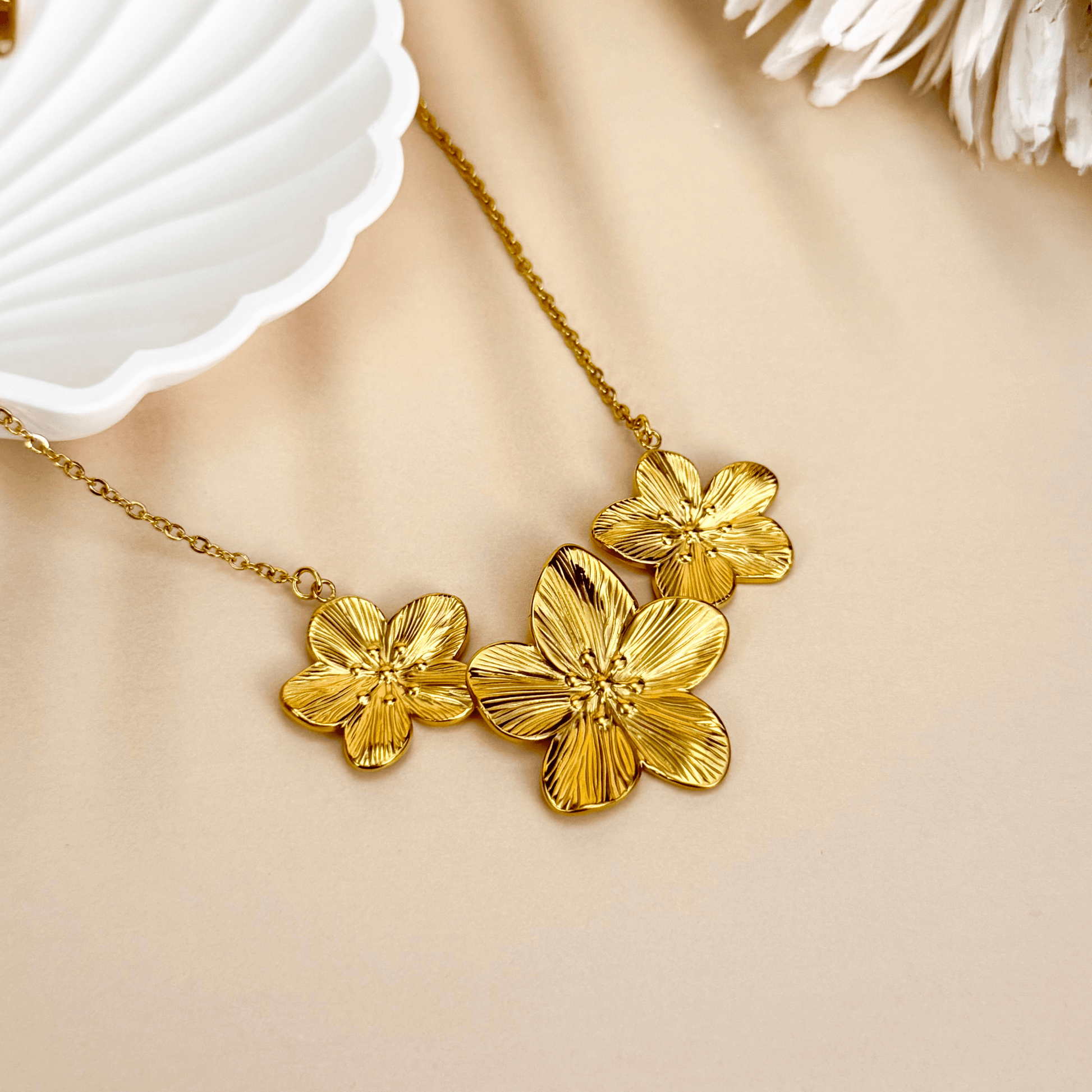 Gold triple flower pendant necklace with detailed floral design, made from waterproof PVD gold-plated stainless steel, displayed on a neutral background.