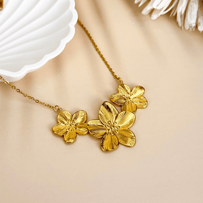 Gold triple flower pendant necklace with detailed floral design, made from waterproof PVD gold-plated stainless steel, displayed on a neutral background.