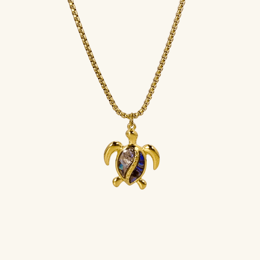 Waterproof gold turtle pendant necklace with abalone shell, shown on model with ocean-inspired details