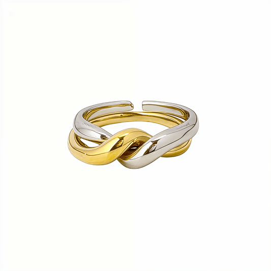 Two-Tone Interlocking Ring by MXW Jewellery featuring interwoven gold and silver bands displayed on a white textured pedestal.
