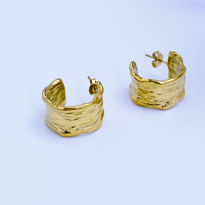 Close-up of molten texture gold hoop earrings