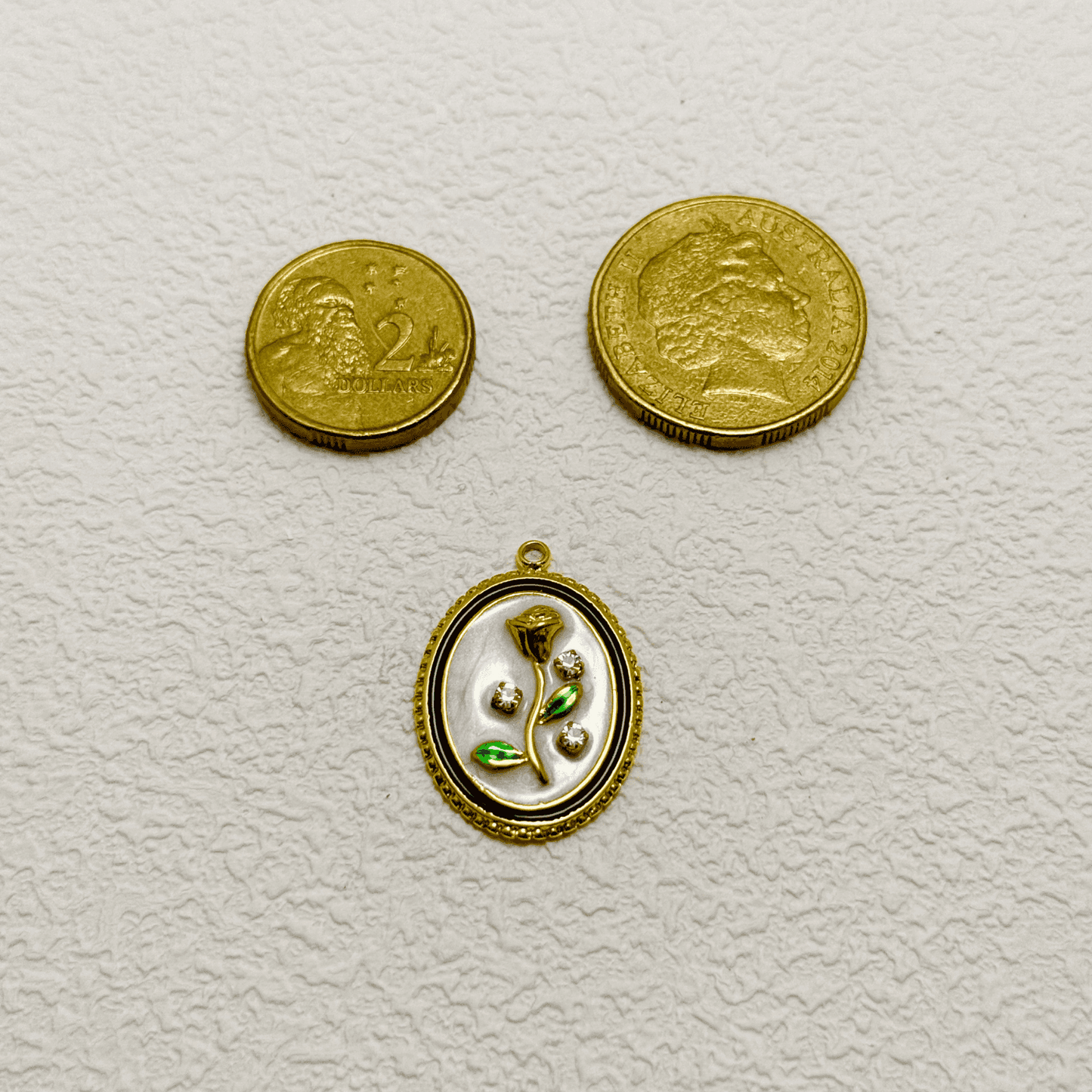 Elegant oval charm with sculpted golden rose, green enamel leaves, and embedded zircon accents on white enamel – floral vintage-style pendant for custom necklaces.
